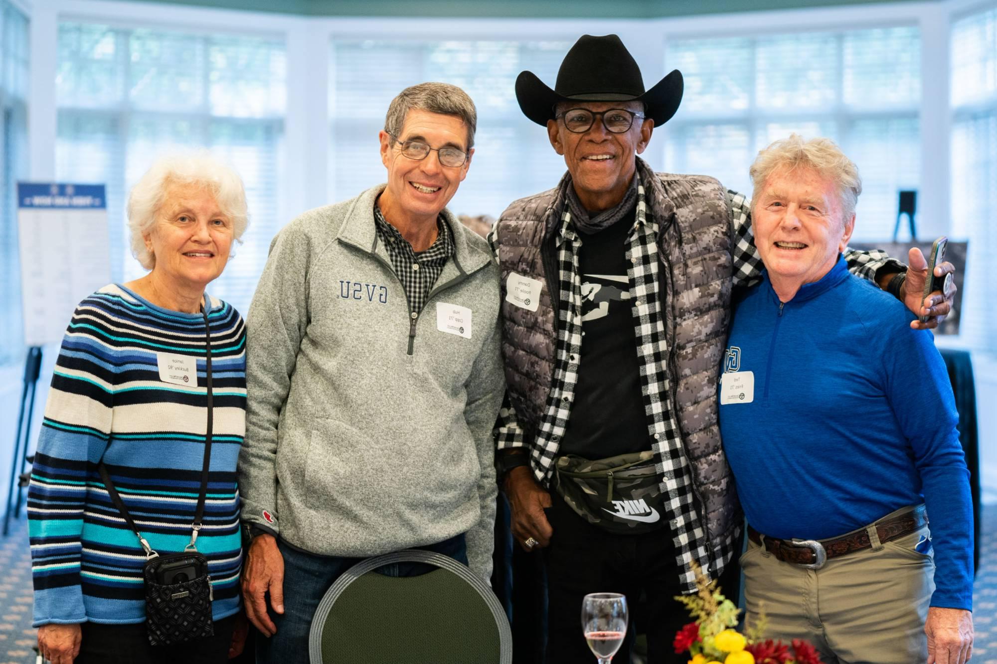 Alumni pose for a group photo in the Alumni House during reunion